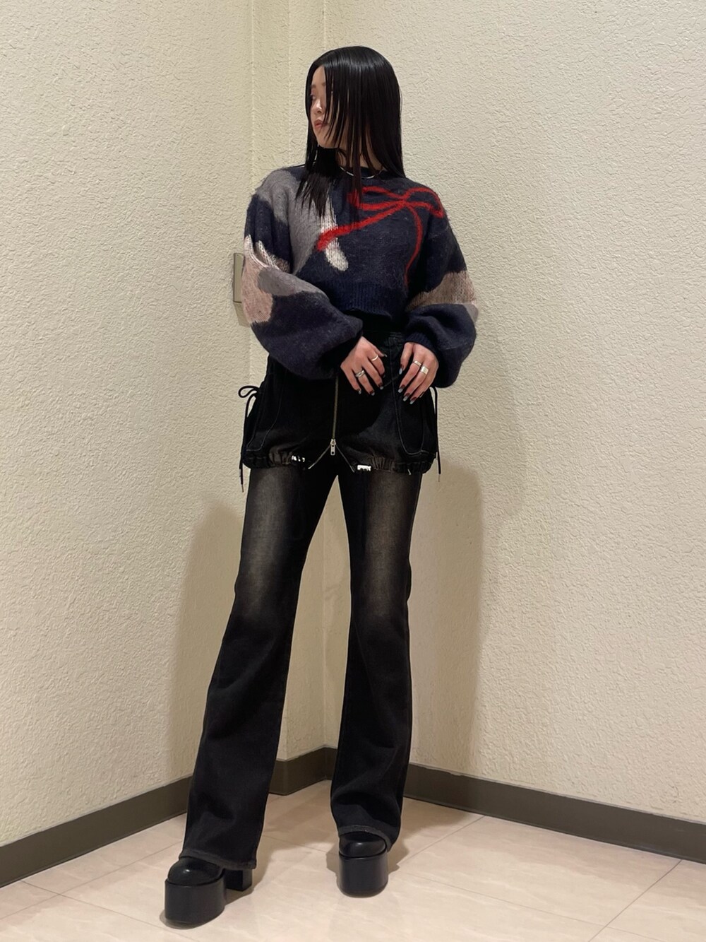 ブラック系のデニムパンツ、ブルー系のニット/セーター、ブラック系のブーツを着用したレディースの秋コーディネートの2枚目の写真