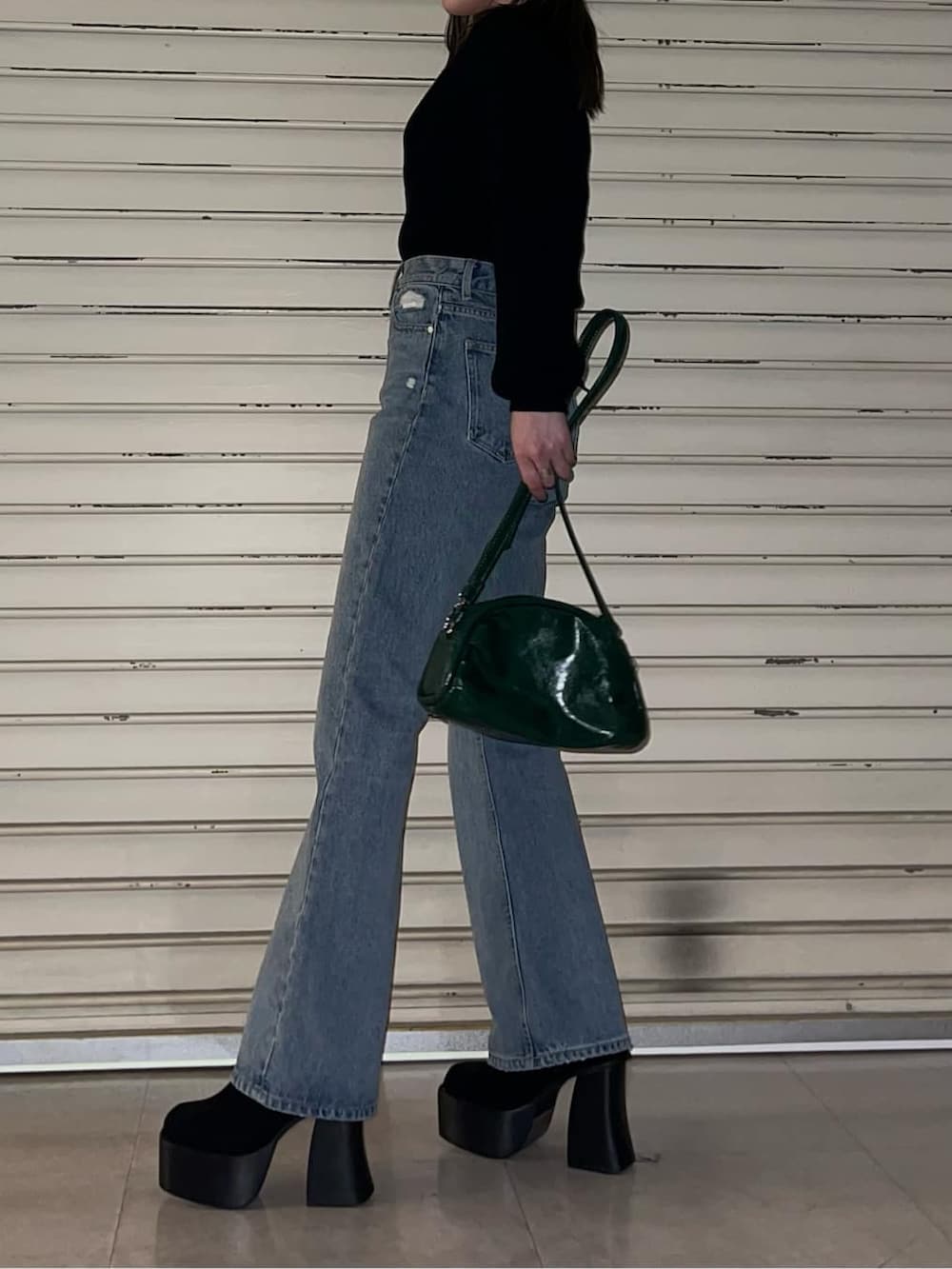 グリーン系のボディバッグ/ウエストポーチ、ブルー系のデニムパンツ、ブラック系のブーツを着用したレディースの秋コーディネートの4枚目の写真