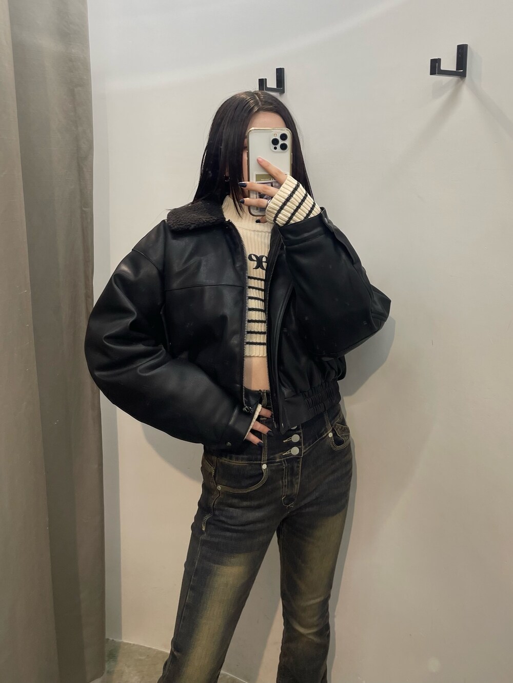 ブルー系のデニムパンツ、ホワイト系のニット/セーター、ブラック系のブルゾンを着用したレディースの秋コーディネートの4枚目の写真