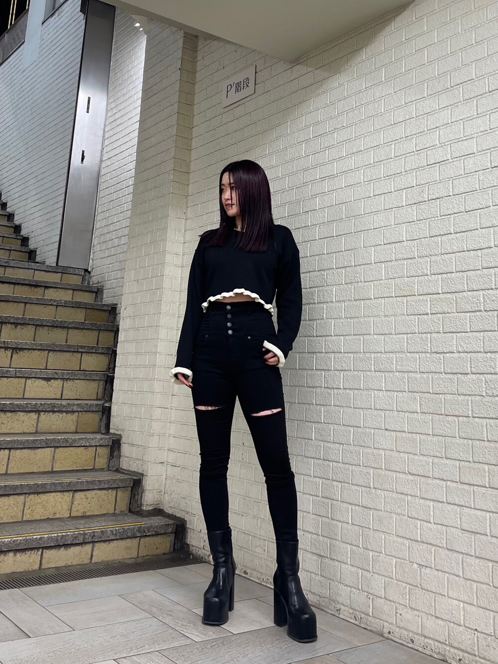 ブラック系のニット/セーター、ブラック系のデニムパンツ、ブラック系のブーツを着用したレディースの冬コーディネートの2枚目の写真