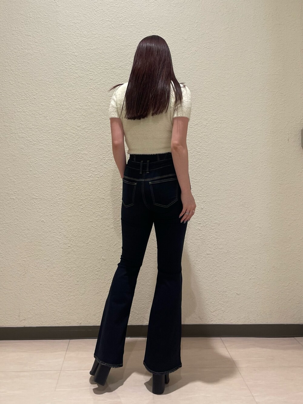 ブルー系のデニムパンツ、ホワイト系のニット/セーター、ブラック系のサンダルを着用したレディースの夏コーディネートの4枚目の写真