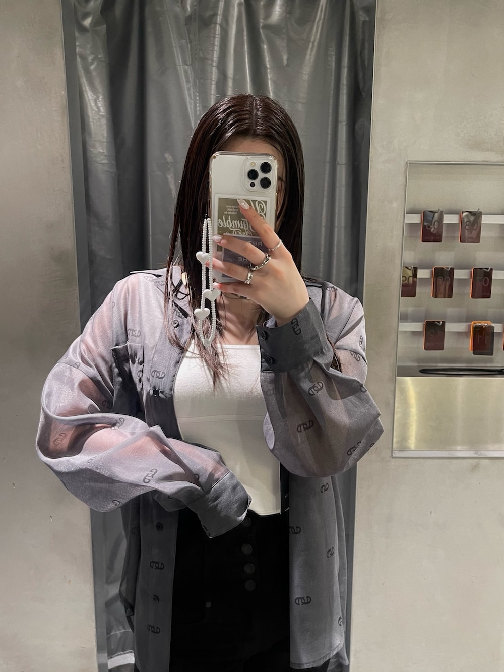 ホワイト系のニット/セーター、ブラック系のシャツ/ブラウス、ブラック系のデニムパンツを着用したレディースの春コーディネートの2枚目の写真