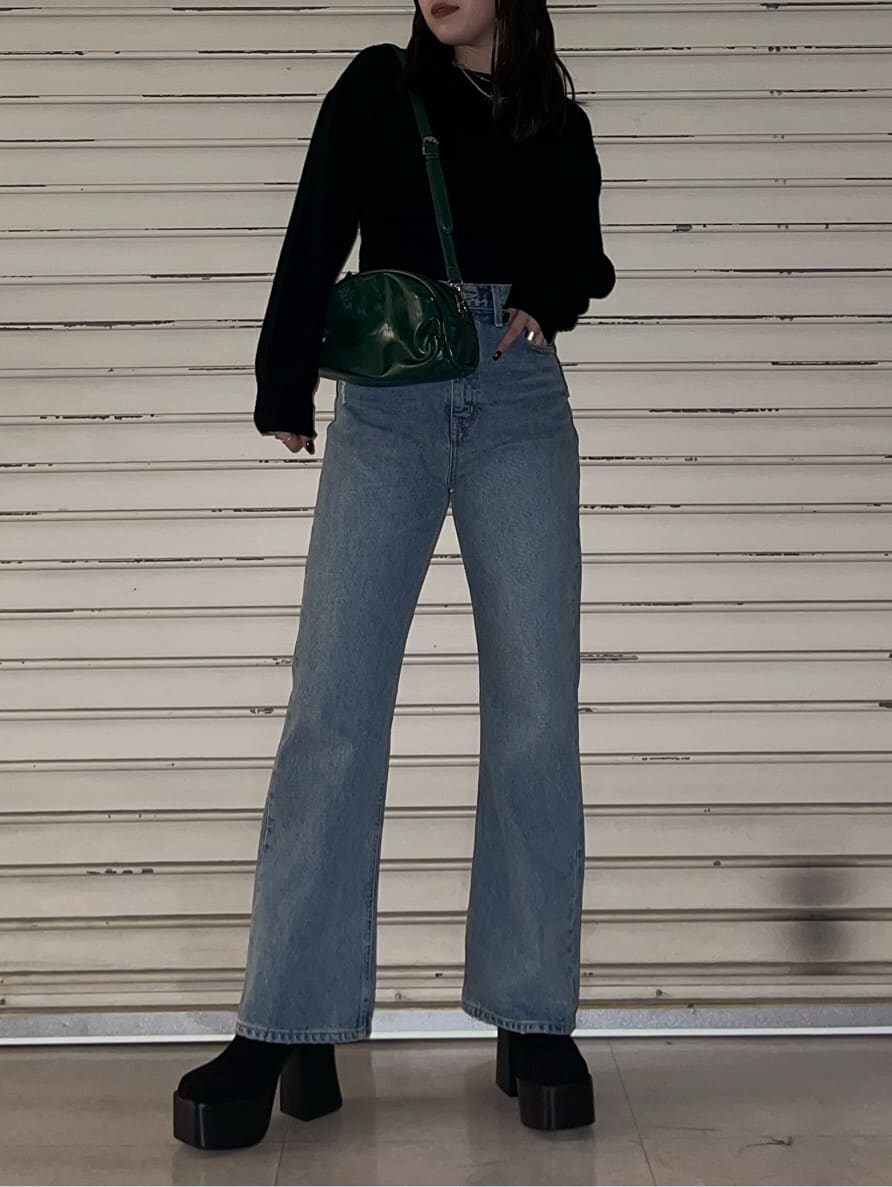 グリーン系のボディバッグ/ウエストポーチ、ブルー系のデニムパンツ、ブラック系のブーツを着用したレディースの秋コーディネートの3枚目の写真