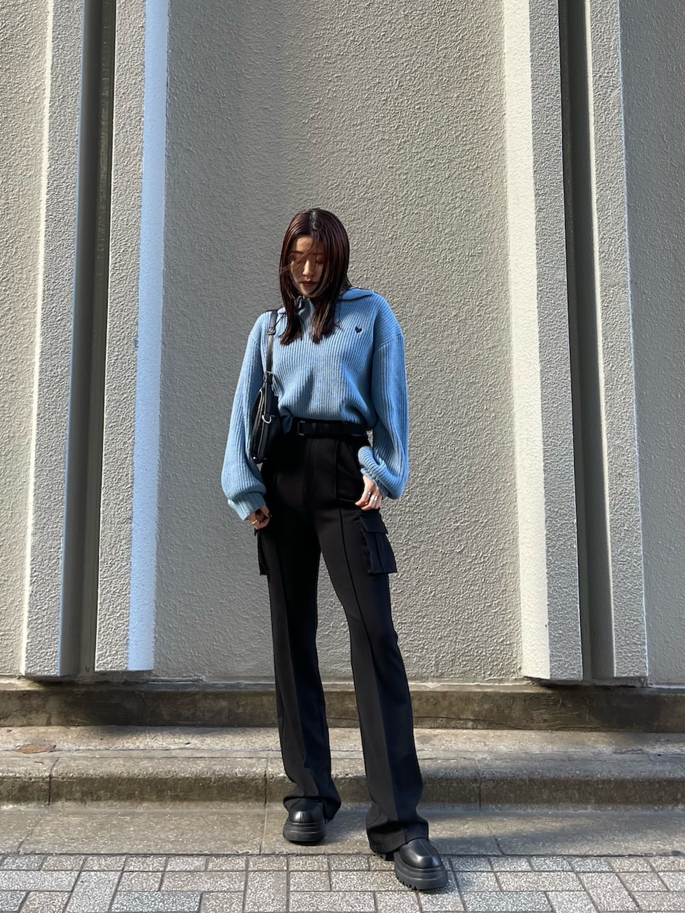 ブルー系のニット/セーター、ブラック系のカーゴパンツ、ブラック系のブーツを着用したレディースの冬コーディネートの3枚目の写真