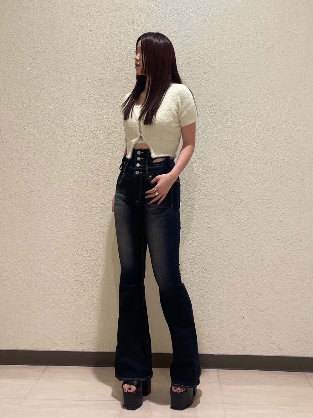 ブルー系のデニムパンツ、ホワイト系のニット/セーター、ブラック系のサンダルを着用したレディースの夏コーディネートの2枚目の写真