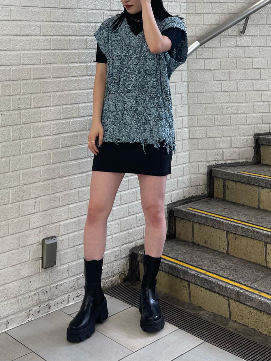 ブラック系のスカート、ブラック系のブーツ、ブラック系のニット/セーターを着用したレディースの夏コーディネートの3枚目の写真