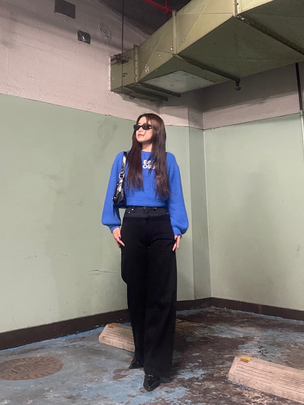 ブルー系のニット/セーター、ブラック系のデニムパンツを着用したレディースの冬コーディネートの3枚目の写真