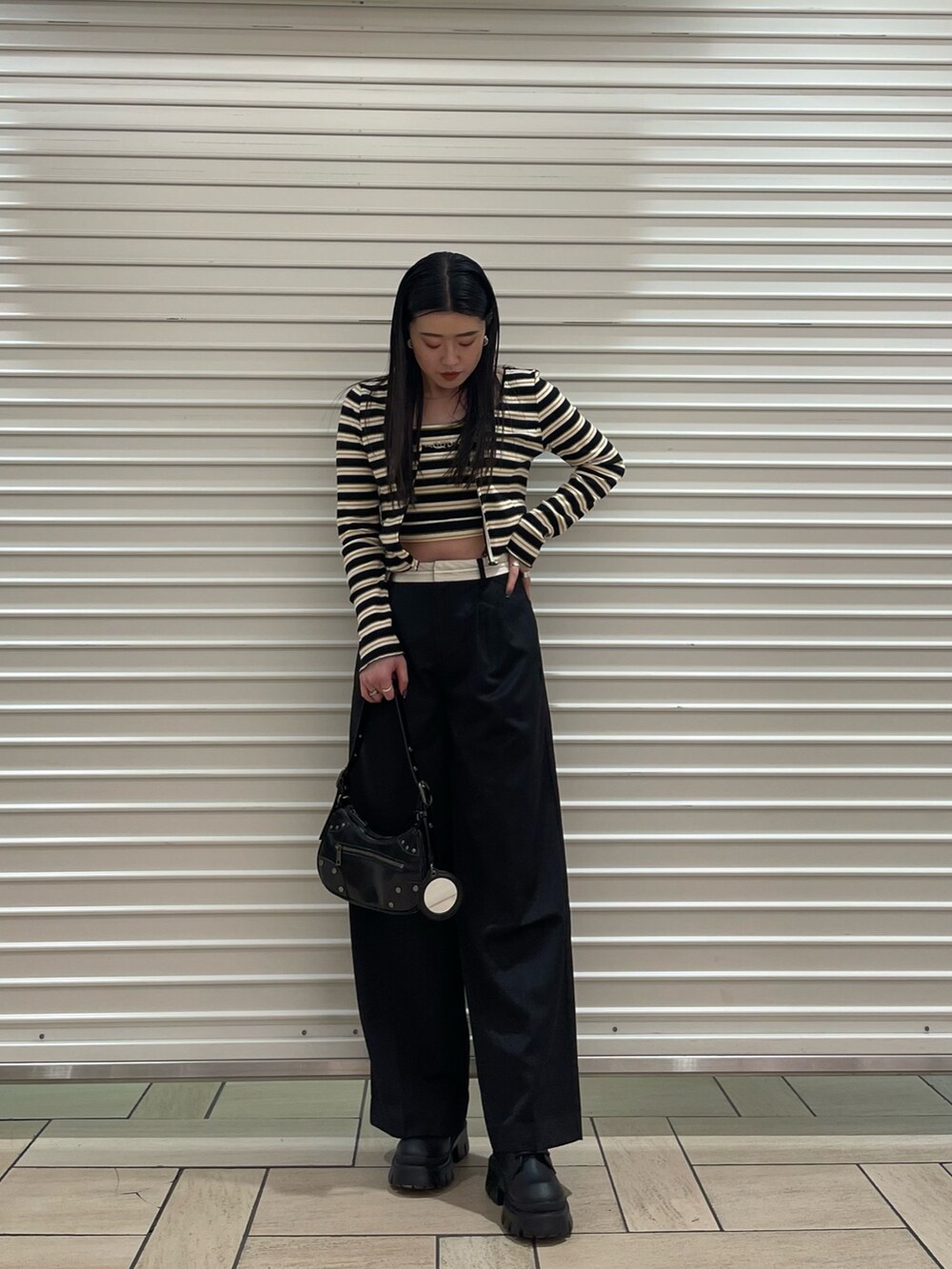 その他のTシャツ/カットソー、ブラック系のその他パンツ、ブラック系のハンドバッグを着用したレディースの春コーディネートの2枚目の写真