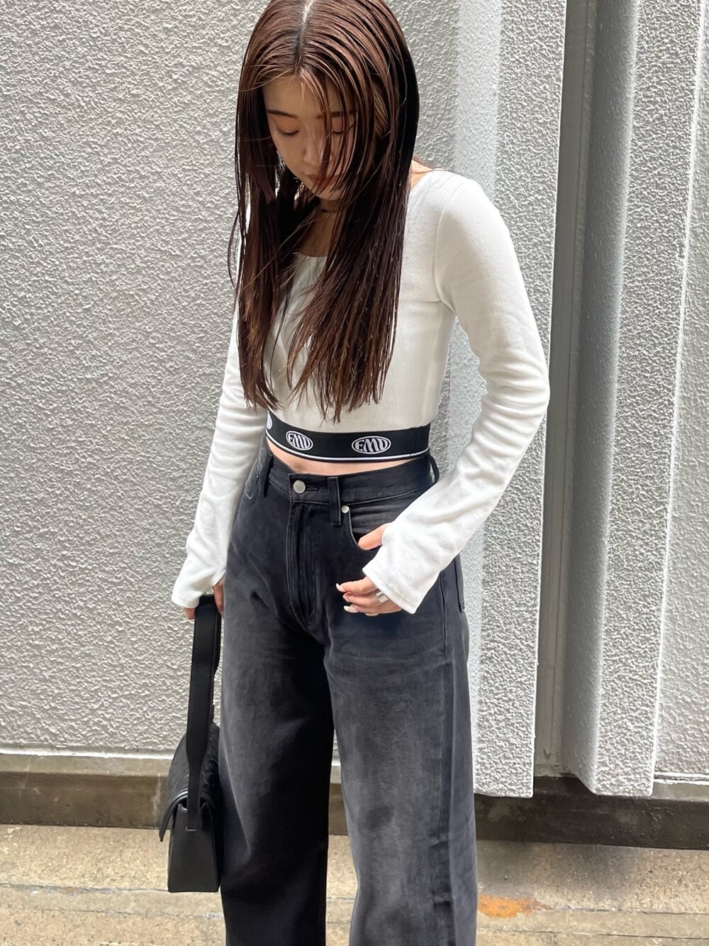 ホワイト系のTシャツ/カットソー、ブラック系のデニムパンツ、ブラック系のハンドバッグを着用したレディースの秋コーディネートの5枚目の写真