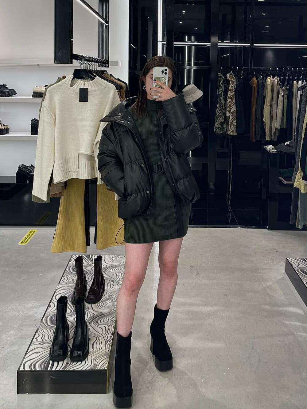 グリーン系のワンピース、ブラック系のブーツ、その他のダウンジャケット/コートを着用したレディースの秋コーディネートの3枚目の写真