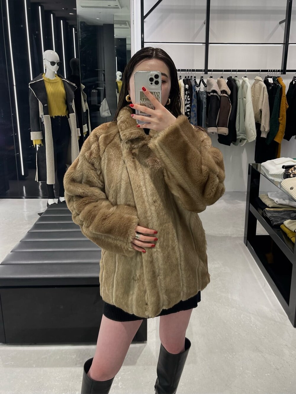 ブラック系のワンピース、ベージュ系のその他アウター、ブラック系のブーツを着用したレディースの冬コーディネートの4枚目の写真