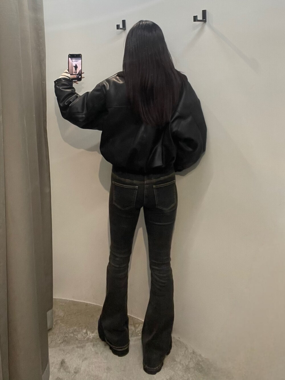 ブルー系のデニムパンツ、ホワイト系のニット/セーター、ブラック系のブルゾンを着用したレディースの秋コーディネートの3枚目の写真