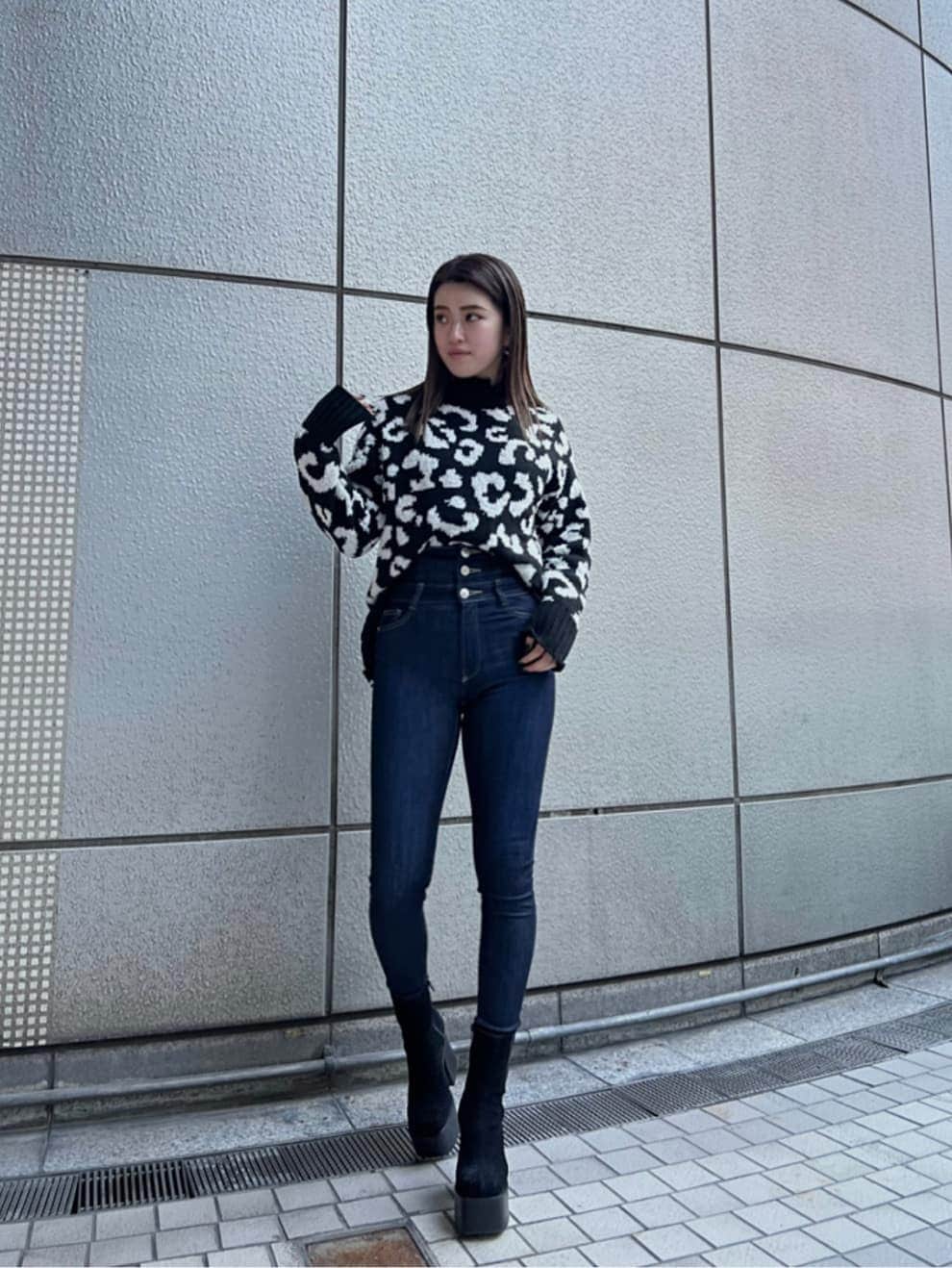 ブラック系のブーツ、ブルー系のデニムパンツ、ブラック系のニット/セーターを着用したレディースの冬コーディネートの2枚目の写真