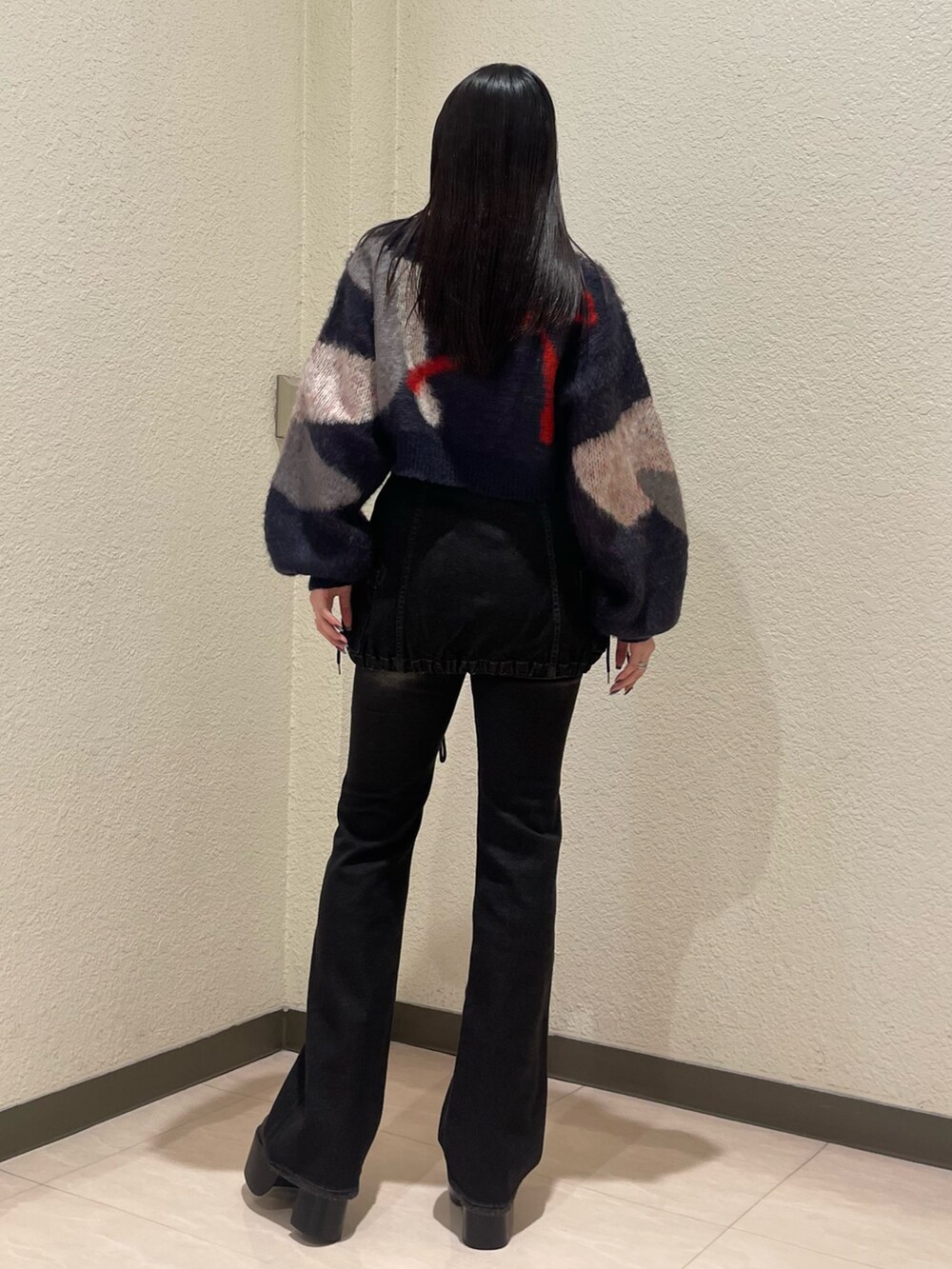 ブラック系のデニムパンツ、ブルー系のニット/セーター、ブラック系のブーツを着用したレディースの秋コーディネートの5枚目の写真