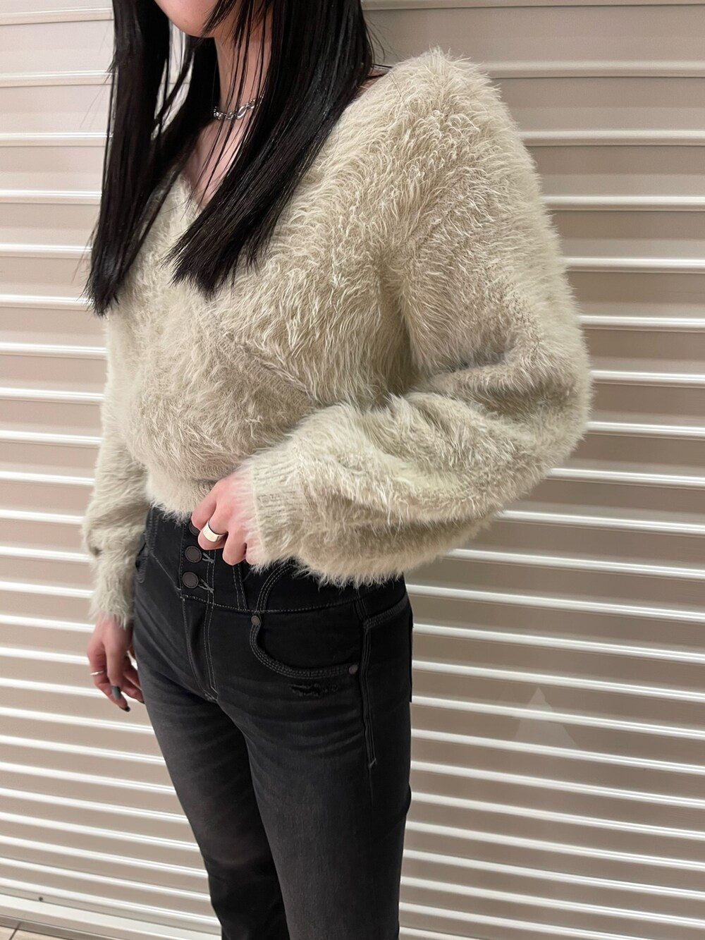 ブラック系のデニムパンツ、ホワイト系のニット/セーター、ブラック系のブーツを着用したレディースの冬コーディネートの6枚目の写真