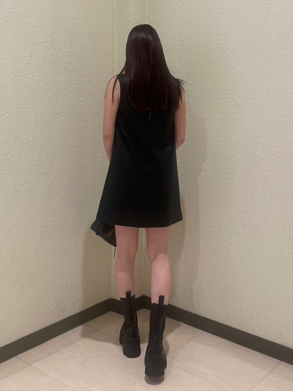 ブラック系のワンピース、ホワイト系のタンクトップ、ブラック系のブーツを着用したレディースの夏コーディネートの5枚目の写真