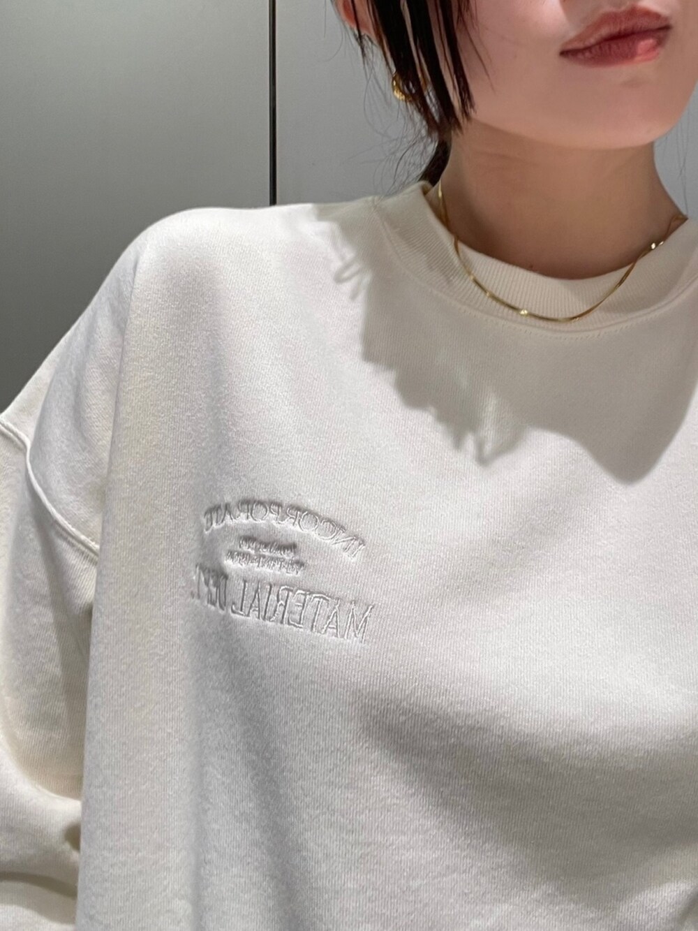 ホワイト系のTシャツ/カットソー、ホワイト系のスウェットパンツ、ブラック系のブーツを着用したレディースの秋コーディネートの4枚目の写真