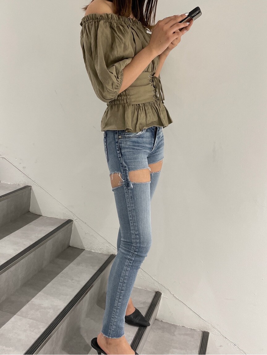 ブラック系のパンプス、ベージュ系のシャツ/ブラウス、ブルー系のデニムパンツを着用したレディースの春コーディネートの3枚目の写真