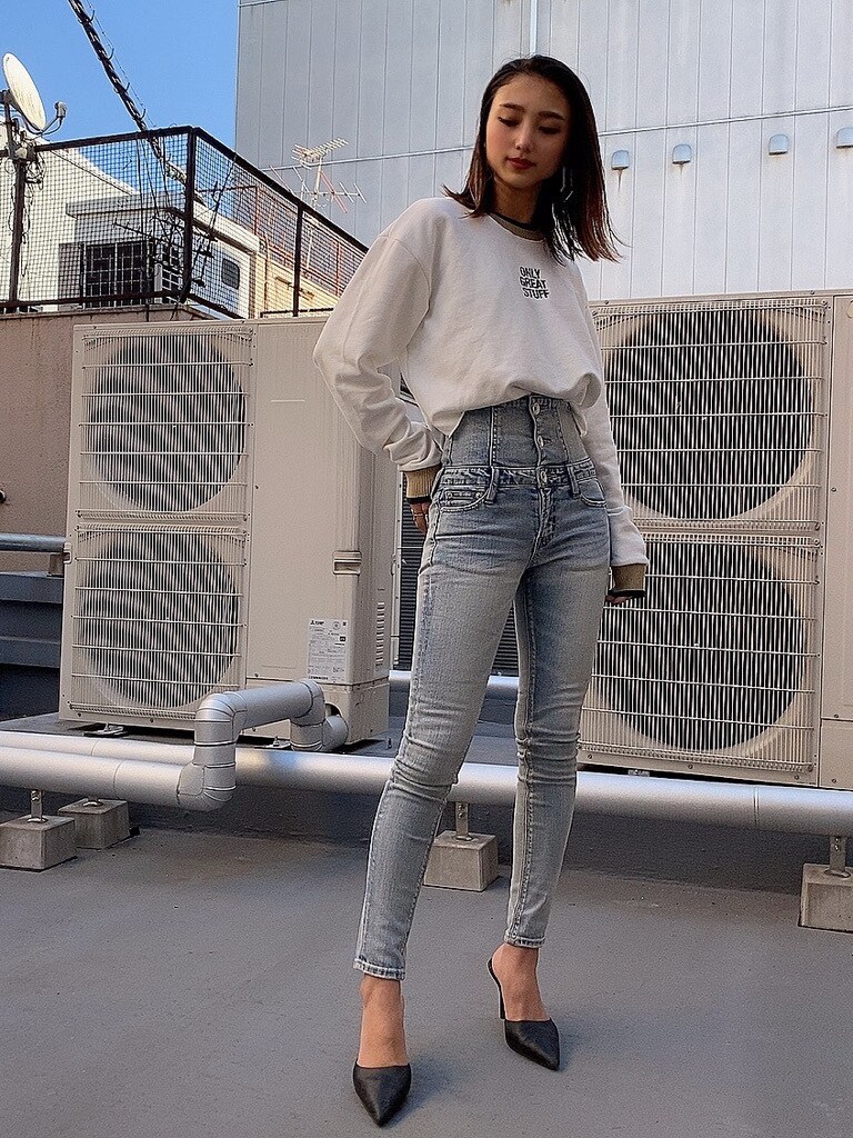 ブルー系のデニムパンツ、ブラック系のパンプスを着用したレディースの冬コーディネートの2枚目の写真