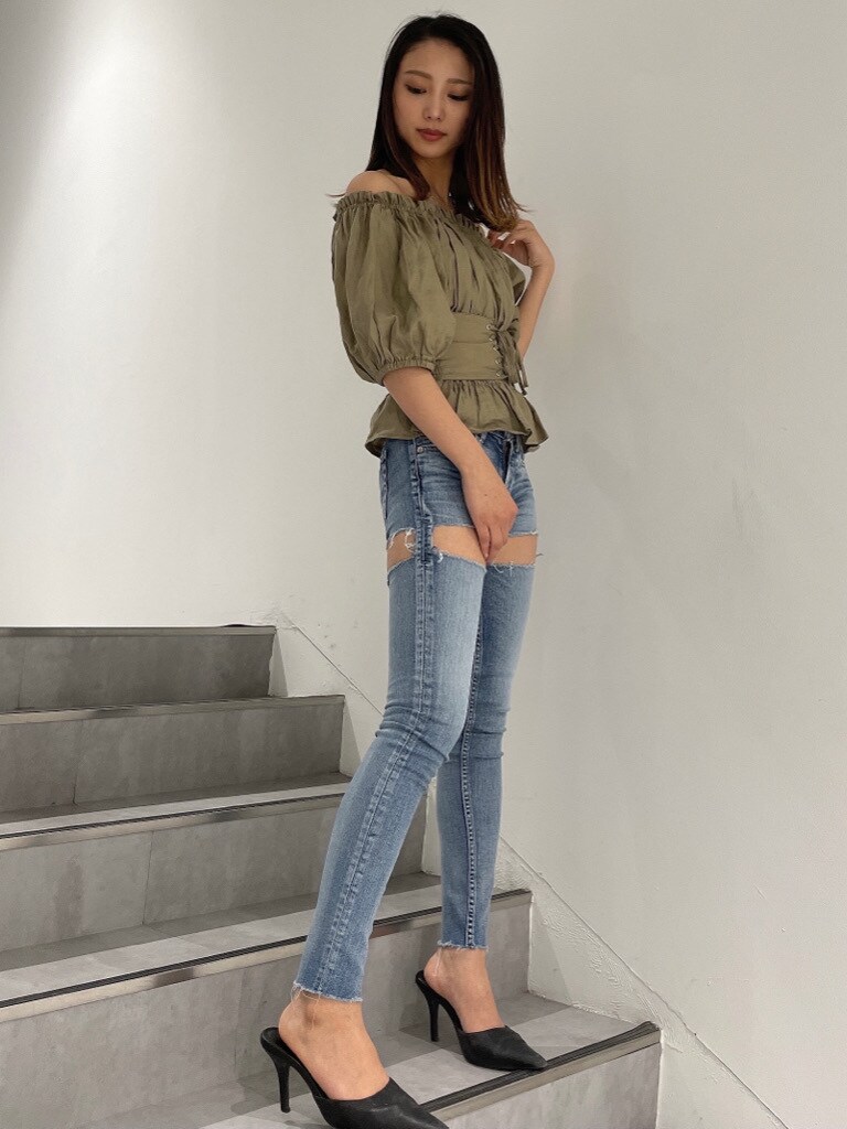 ブラック系のパンプス、ベージュ系のシャツ/ブラウス、ブルー系のデニムパンツを着用したレディースの春コーディネートの2枚目の写真