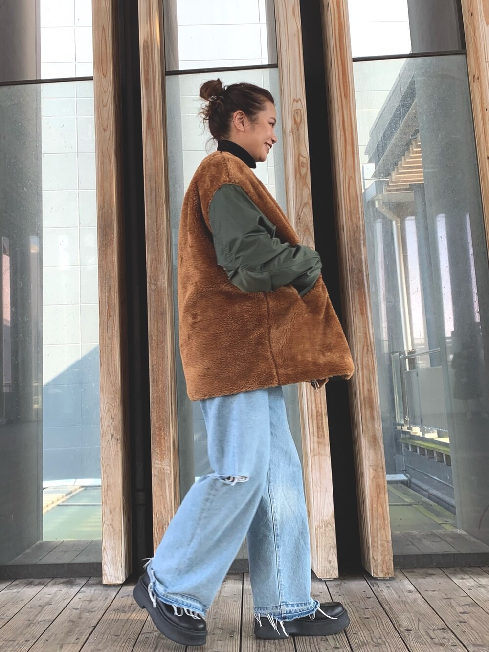 ブルー系のデニムパンツ、ブラック系のニット/セーター、グリーン系のブルゾンを着用したレディースの秋コーディネートの4枚目の写真