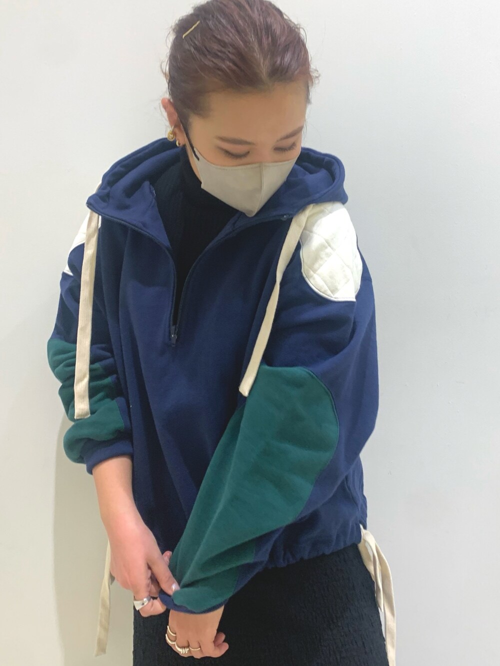 ブルー系のパーカー、ブラック系のスカート、ブラック系のハンドバッグを着用したレディースの冬コーディネートの4枚目の写真