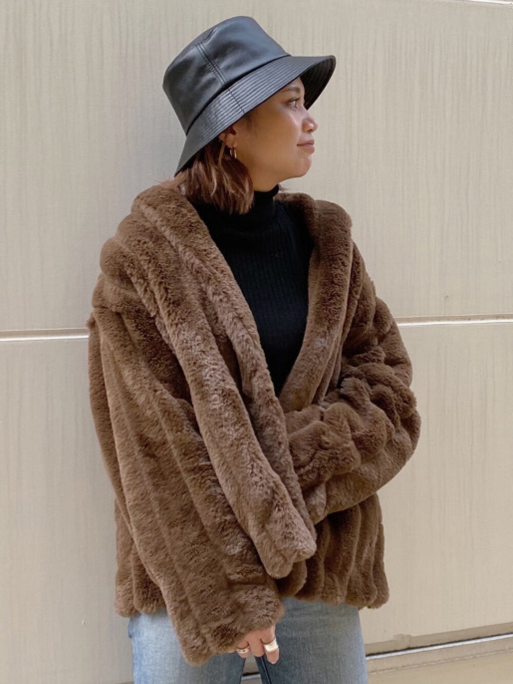 ブラウン系のその他アウター、ブルー系のデニムパンツ、ブラック系のニット/セーターを着用したレディースの秋コーディネートの2枚目の写真