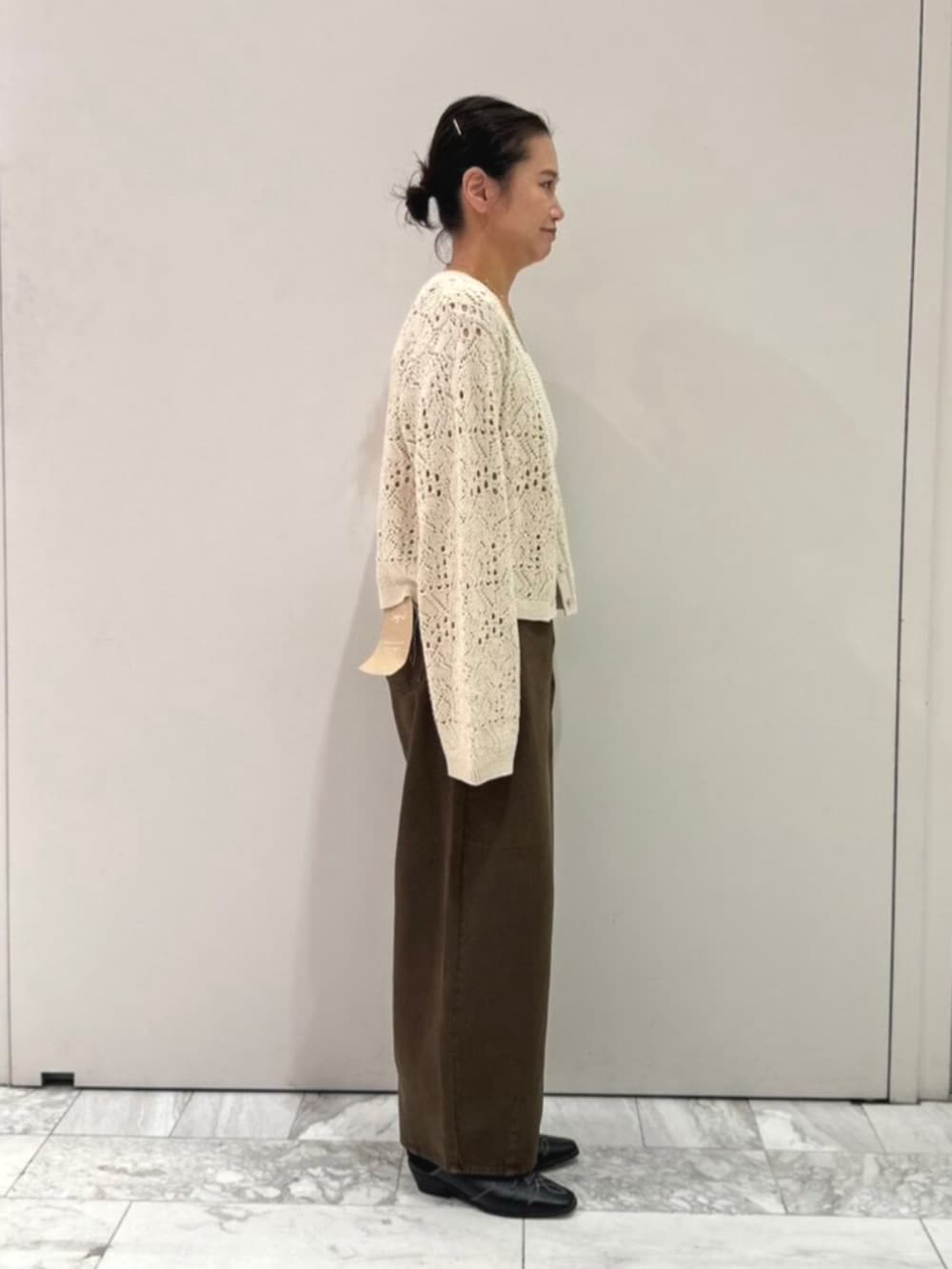 ブラック系のその他シューズ、ブラウン系のデニムパンツ、ホワイト系のアンサンブルを着用したレディースの秋コーディネートの4枚目の写真