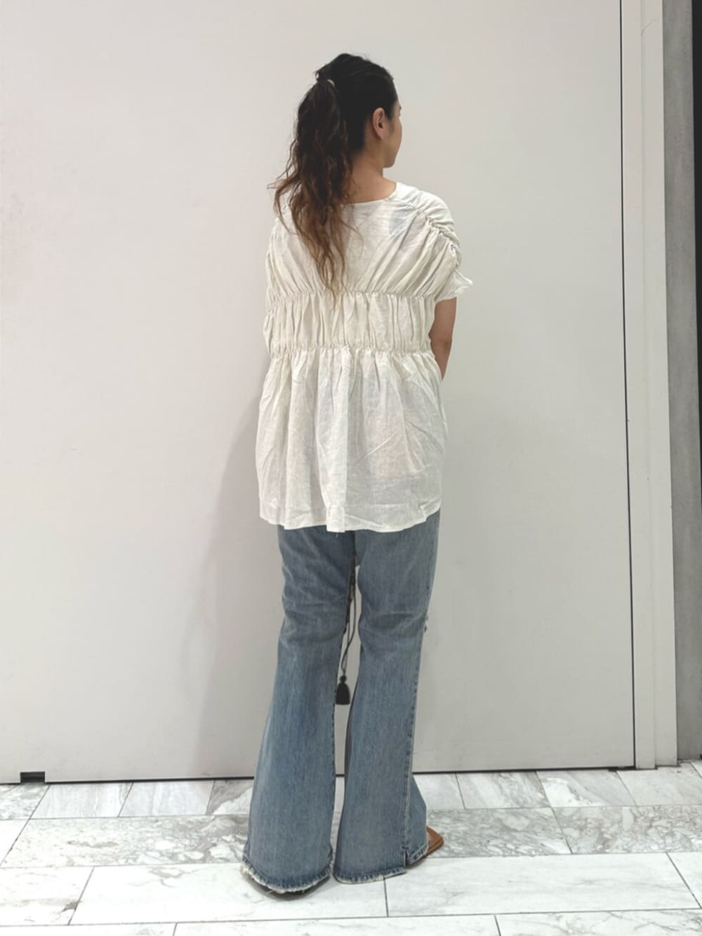 ホワイト系のシャツ/ブラウス、ブルー系のデニムパンツ、その他のサンダルを着用したレディースの夏コーディネートの3枚目の写真