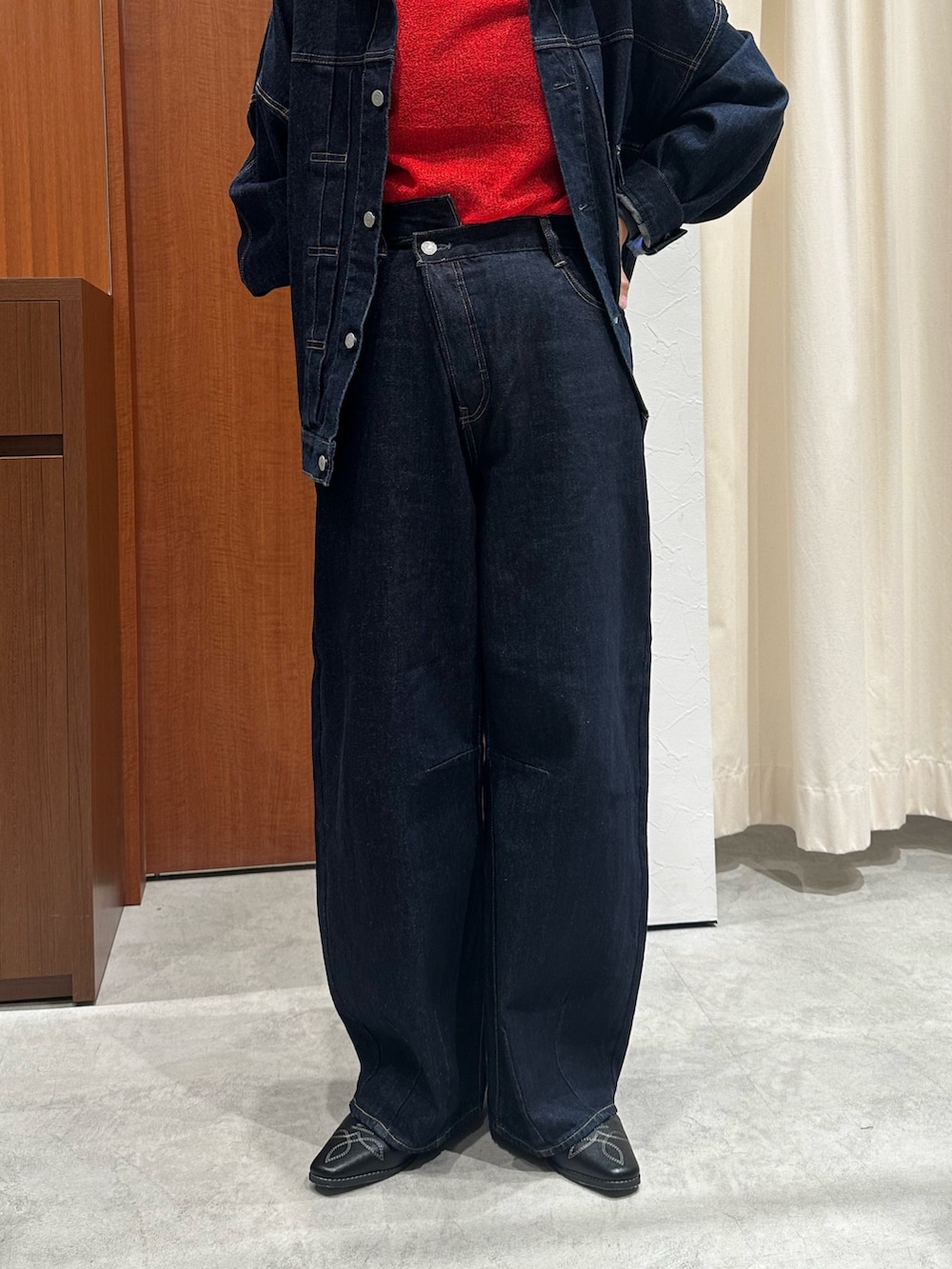 レッド系のニット/セーター、ブラウン系のその他シューズ、ブルー系のデニムパンツを着用したレディースの秋コーディネートの6枚目の写真