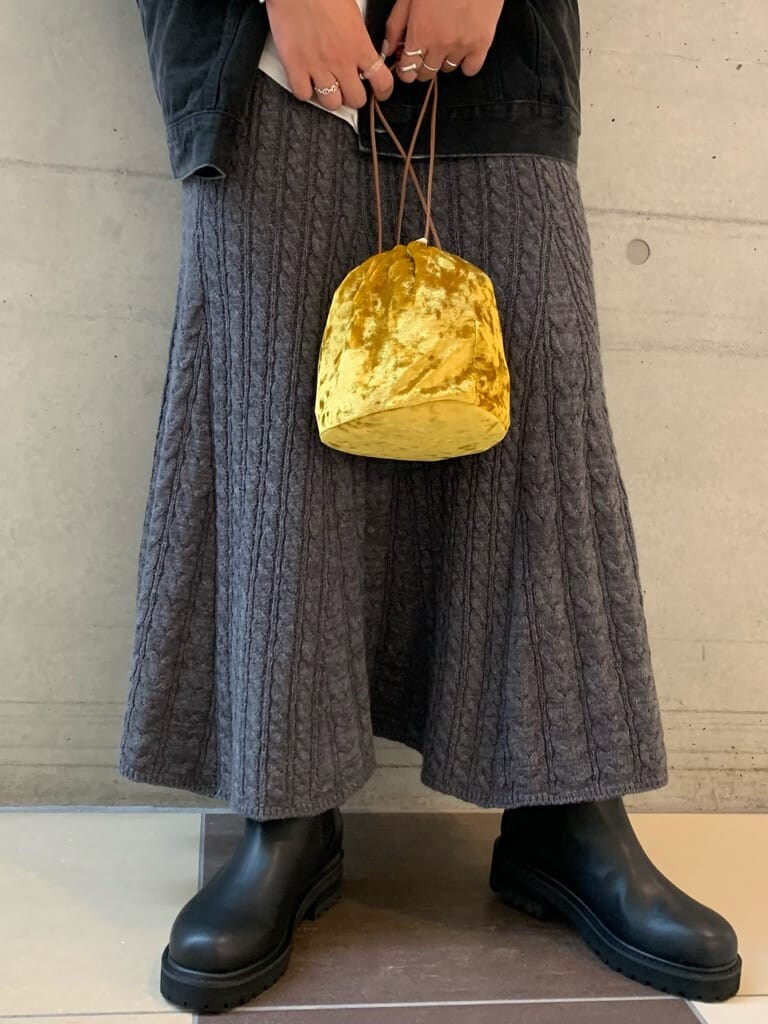 ブラック系のデニムジャケット、グレー系のスカート、イエロー系のハンドバッグを着用したレディースの秋コーディネートの4枚目の写真