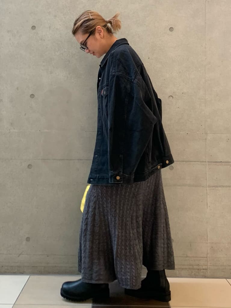 ブラック系のデニムジャケット、グレー系のスカート、イエロー系のハンドバッグを着用したレディースの秋コーディネートの3枚目の写真