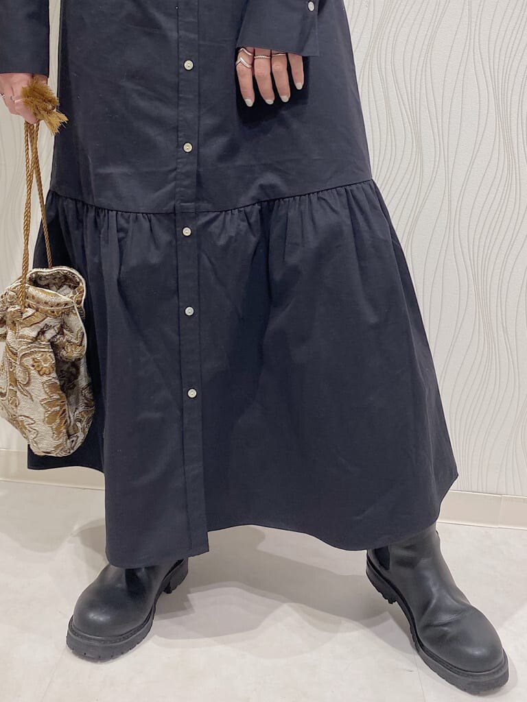 ホワイト系のハンドバッグ、ブラック系のワンピース、グレー系のニット/セーターを着用したレディースの秋コーディネートの3枚目の写真