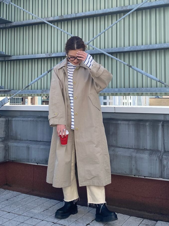 ブルー系のTシャツ/カットソー、ベージュ系のステンカラーコート、ホワイト系のデニムパンツを着用したレディースの冬コーディネートの2枚目の写真