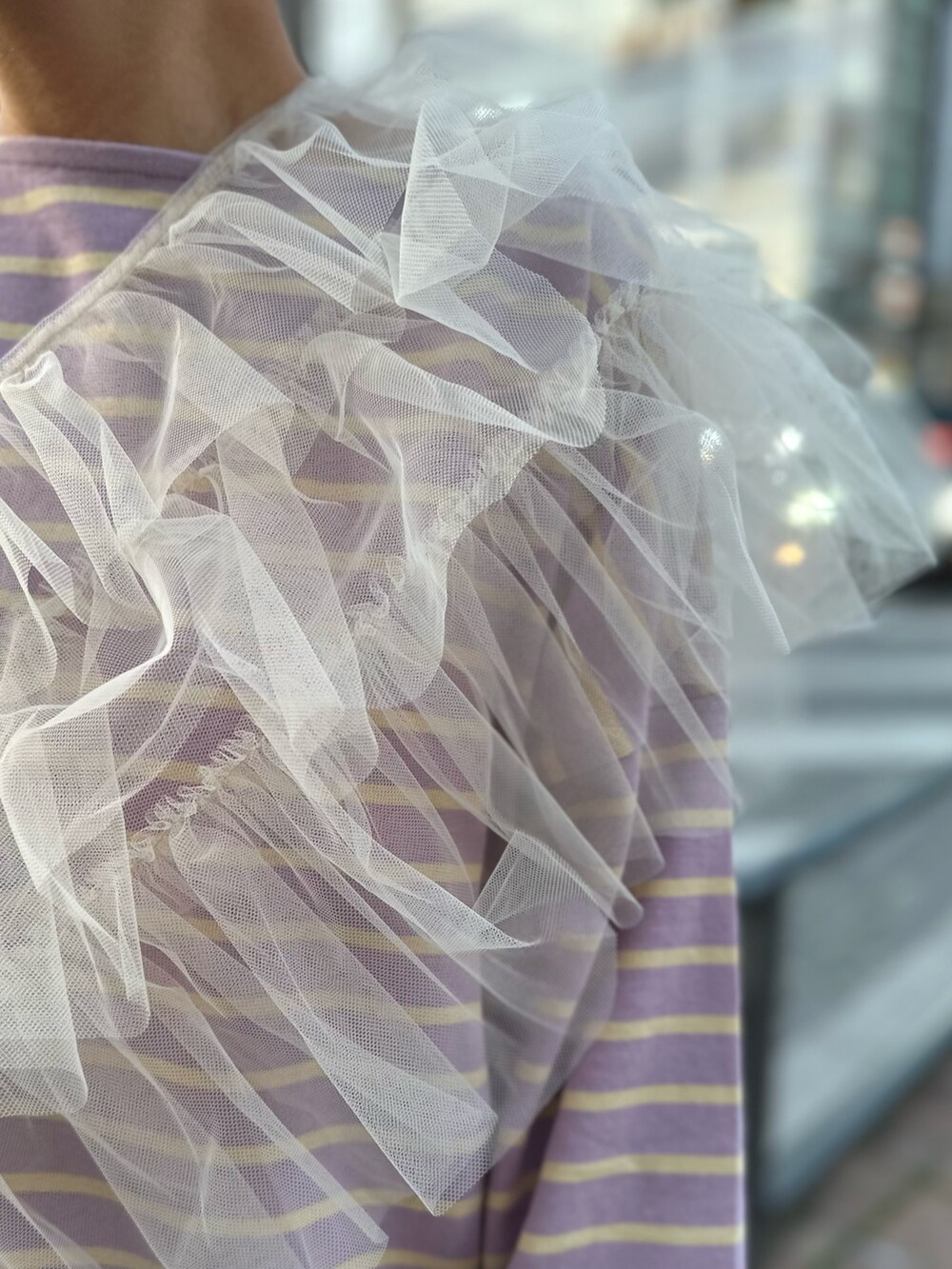 ベージュ系のベスト、ホワイト系のその他パンツ、ブラック系のショルダーバッグを着用したレディースの冬コーディネートの5枚目の写真