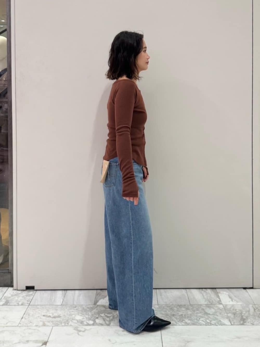ブラウン系のTシャツ/カットソー、ブルー系のデニムパンツを着用したレディースの秋コーディネートの4枚目の写真