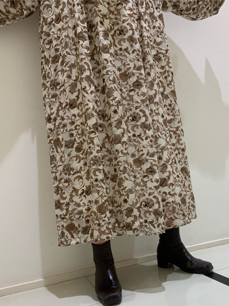 ホワイト系のワンピース、ブラウン系のブーツを着用したレディースの夏コーディネートの3枚目の写真