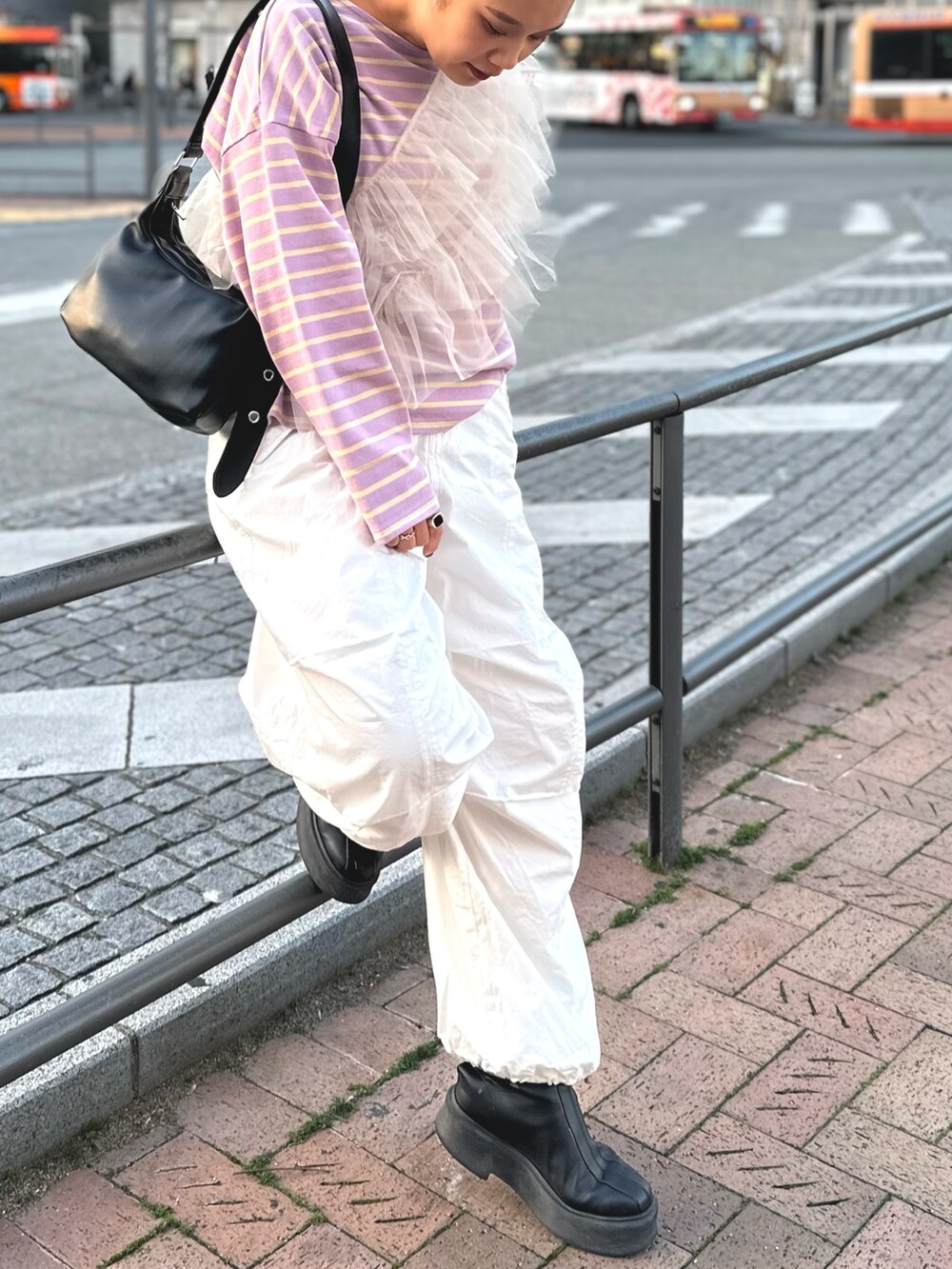 ベージュ系のベスト、ホワイト系のその他パンツ、ブラック系のショルダーバッグを着用したレディースの冬コーディネートの2枚目の写真