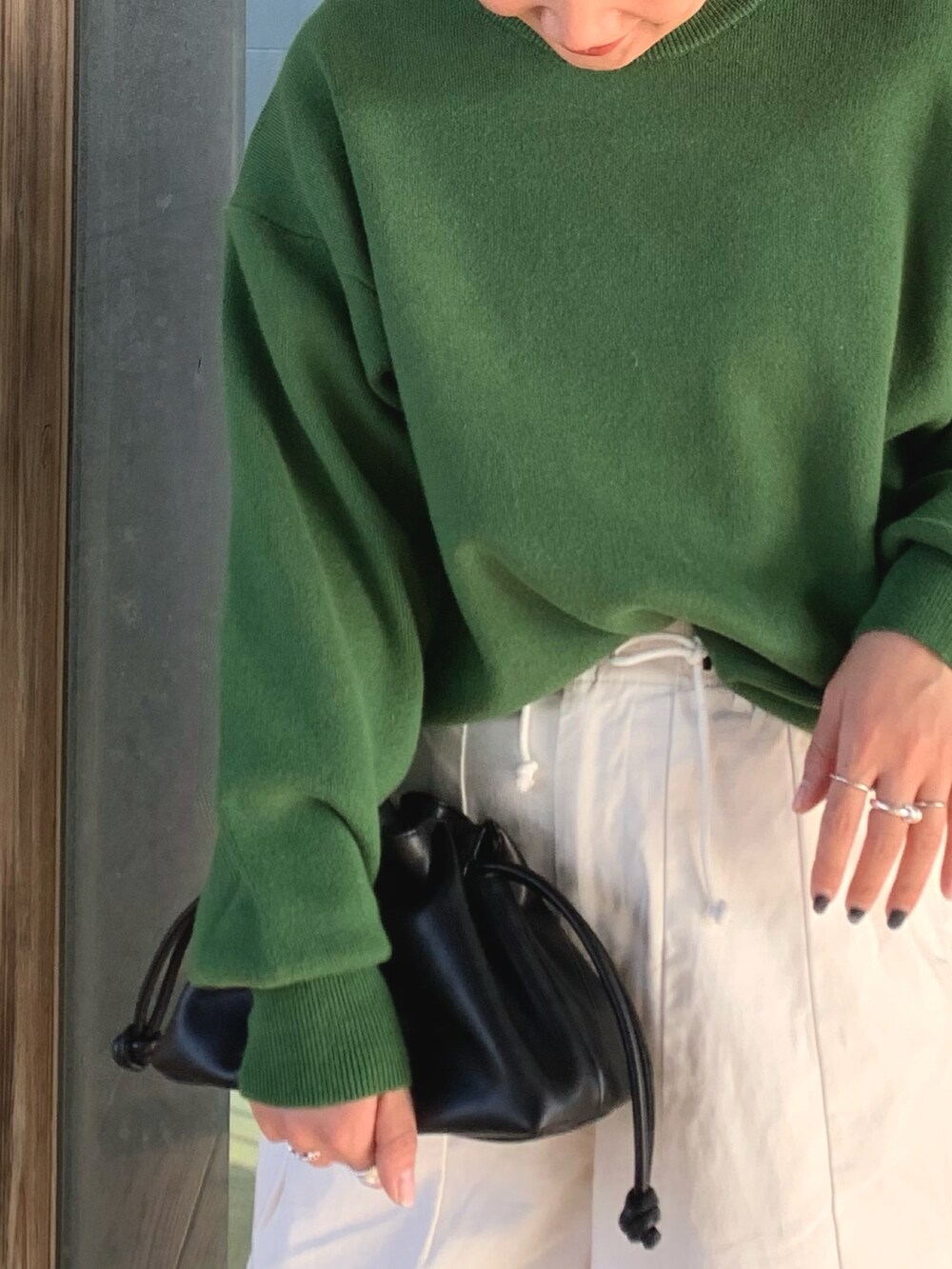 ブラック系のクラッチバッグ、ホワイト系のその他パンツ、グリーン系のニット/セーターを着用したレディースの冬コーディネートの3枚目の写真