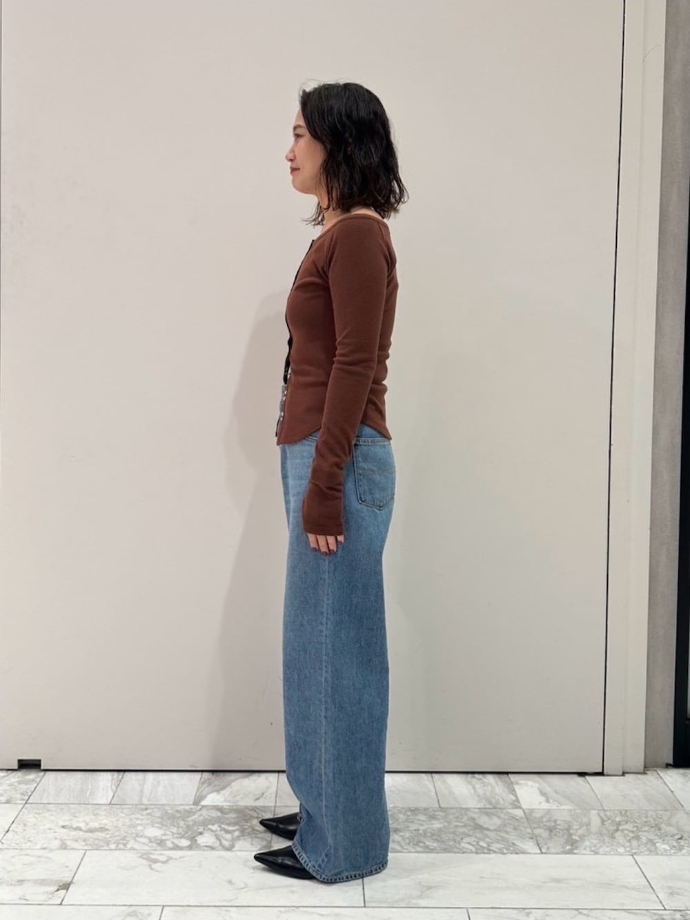 ブラウン系のTシャツ/カットソー、ブルー系のデニムパンツを着用したレディースの秋コーディネートの2枚目の写真