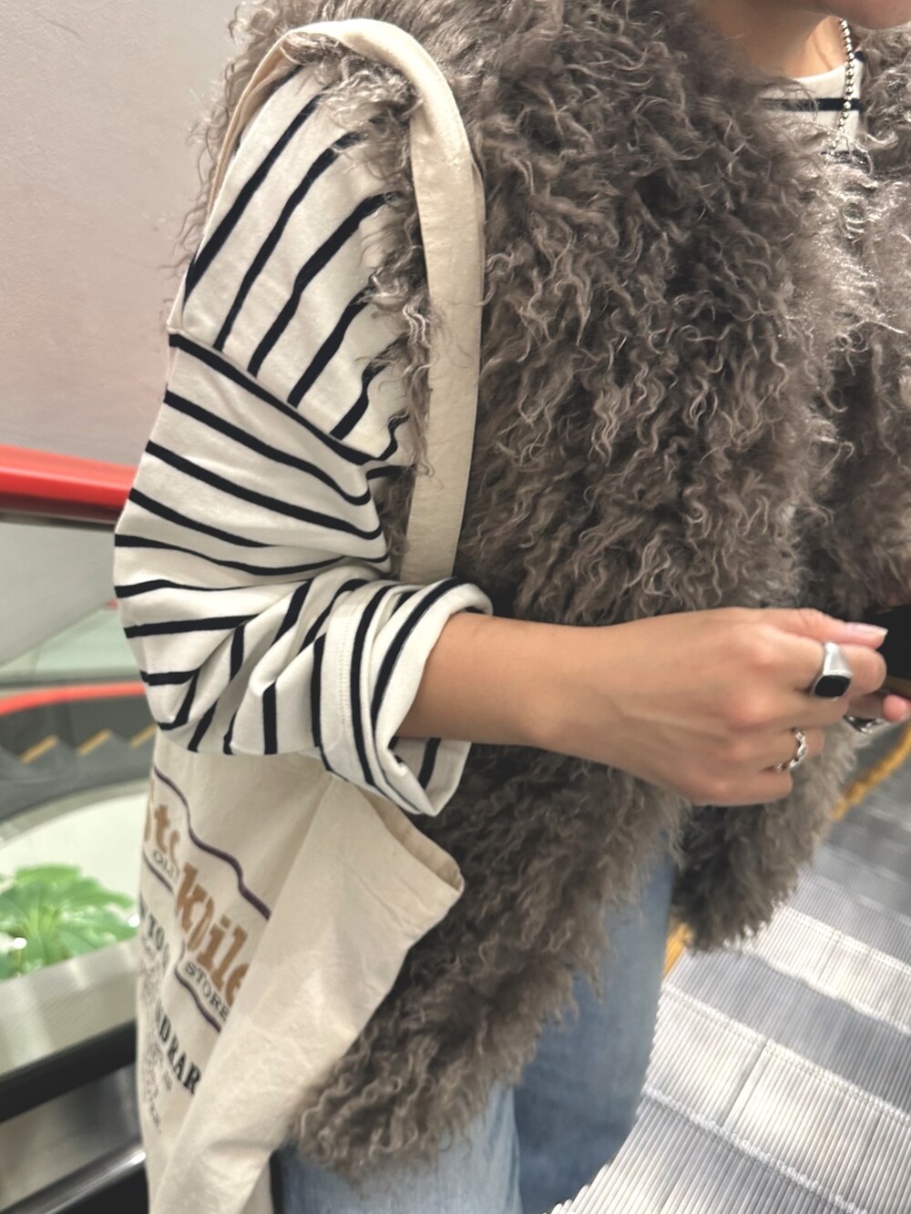 ブルー系のTシャツ/カットソー、ブルー系のデニムパンツ、グレー系のベストを着用したレディースの秋コーディネートの3枚目の写真