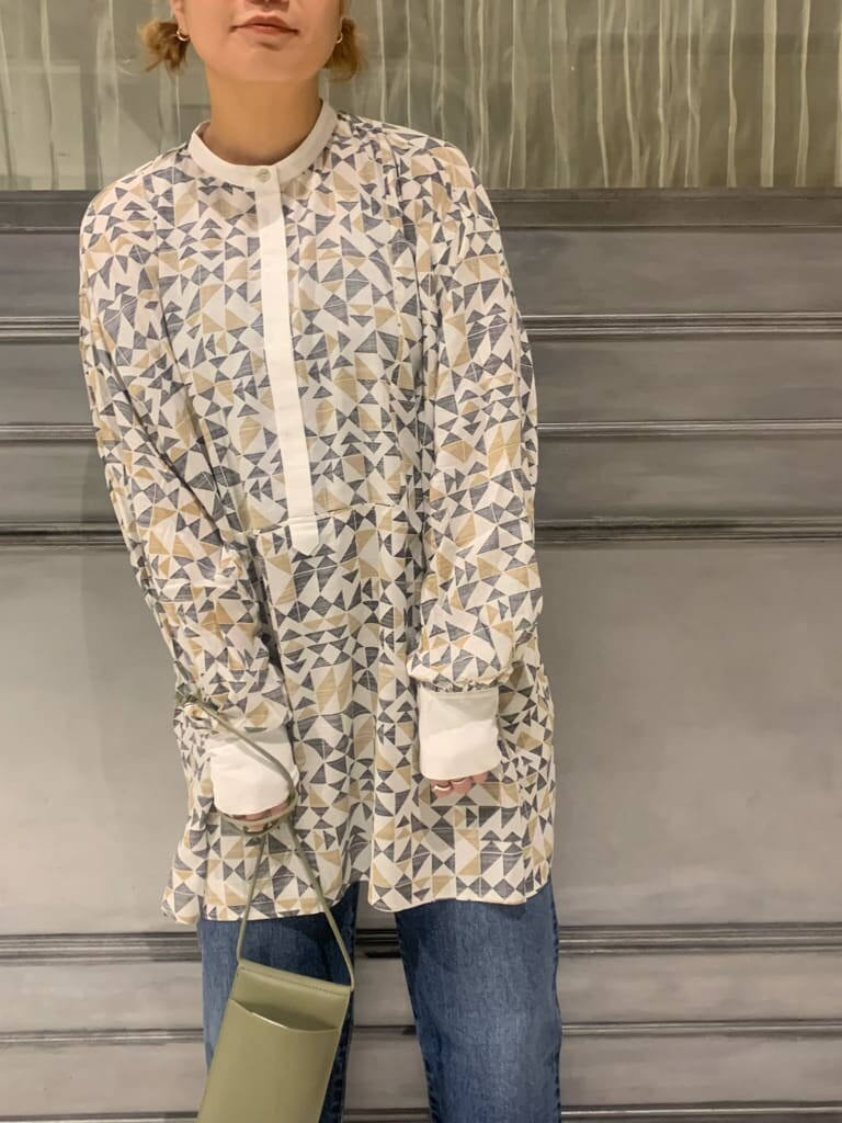 ホワイト系のポンチョ、ブラウン系のシャツ/ブラウス、ブルー系のデニムパンツを着用したレディースの秋コーディネートの4枚目の写真