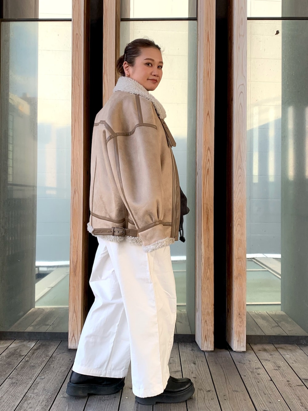 グレー系のスウェット、ホワイト系のその他パンツ、ベージュ系のムートンコートを着用したレディースの冬コーディネートの3枚目の写真