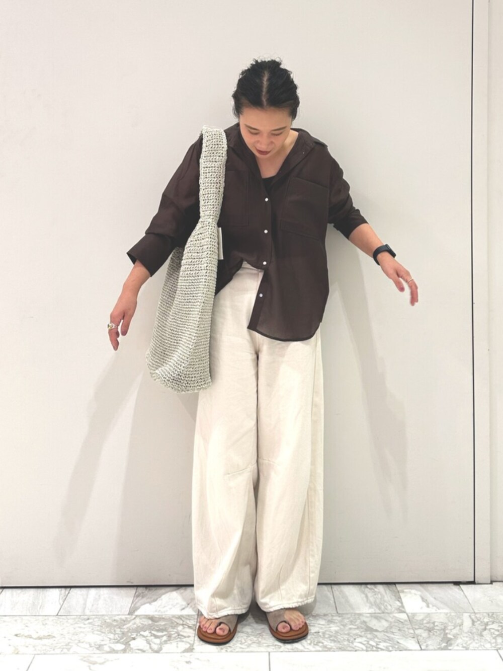 ブラウン系のシャツ/ブラウス、ホワイト系のデニムパンツ、グレー系のショルダーバッグを着用したレディースの夏コーディネートの2枚目の写真