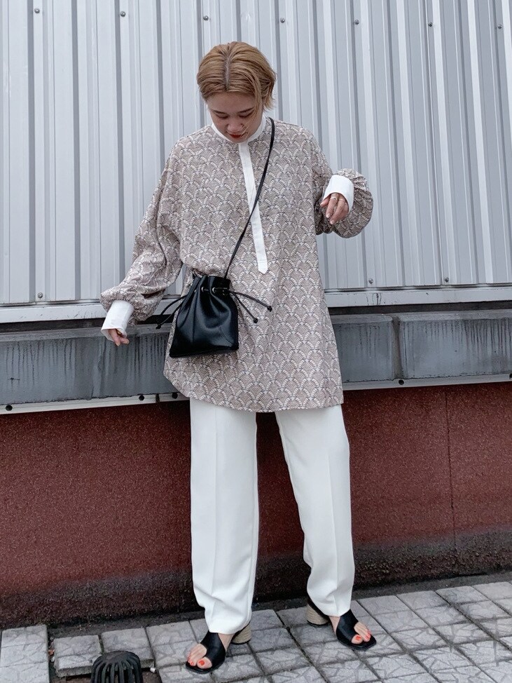 ホワイト系のその他パンツ、ブラック系のサンダル、ブラック系のハンドバッグを着用したレディースの春コーディネートの2枚目の写真