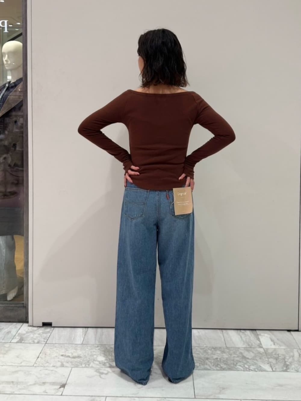 ブラウン系のTシャツ/カットソー、ブルー系のデニムパンツを着用したレディースの秋コーディネートの3枚目の写真