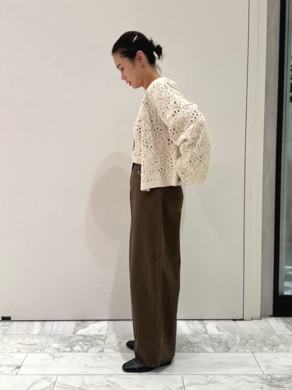 ブラック系のその他シューズ、ブラウン系のデニムパンツ、ホワイト系のアンサンブルを着用したレディースの秋コーディネートの2枚目の写真