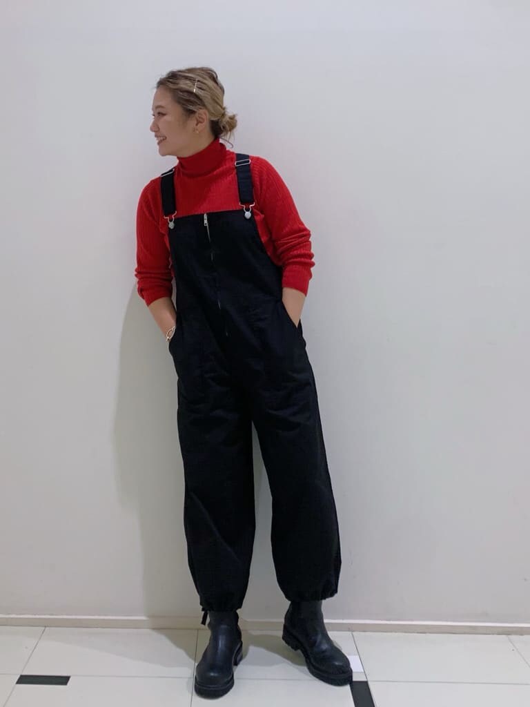 ブラック系のつなぎ/オールインワン、ブラック系のブーツ、レッド系のニット/セーターを着用したレディースの秋コーディネートの3枚目の写真