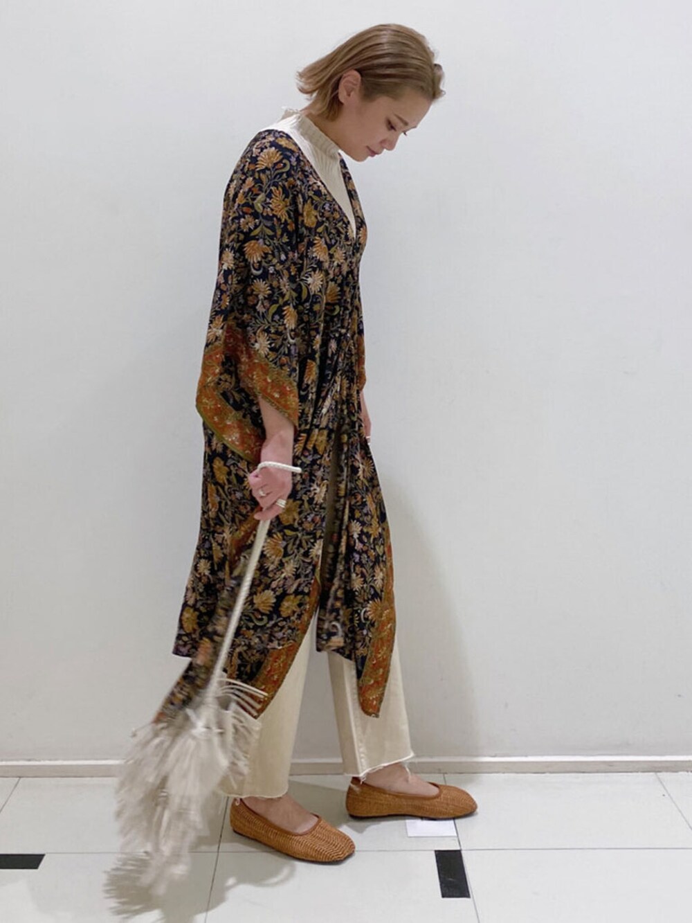 ホワイト系のハンドバッグ、ブラック系のシャツ/ブラウス、ホワイト系のデニムパンツを着用したレディースの冬コーディネートの2枚目の写真