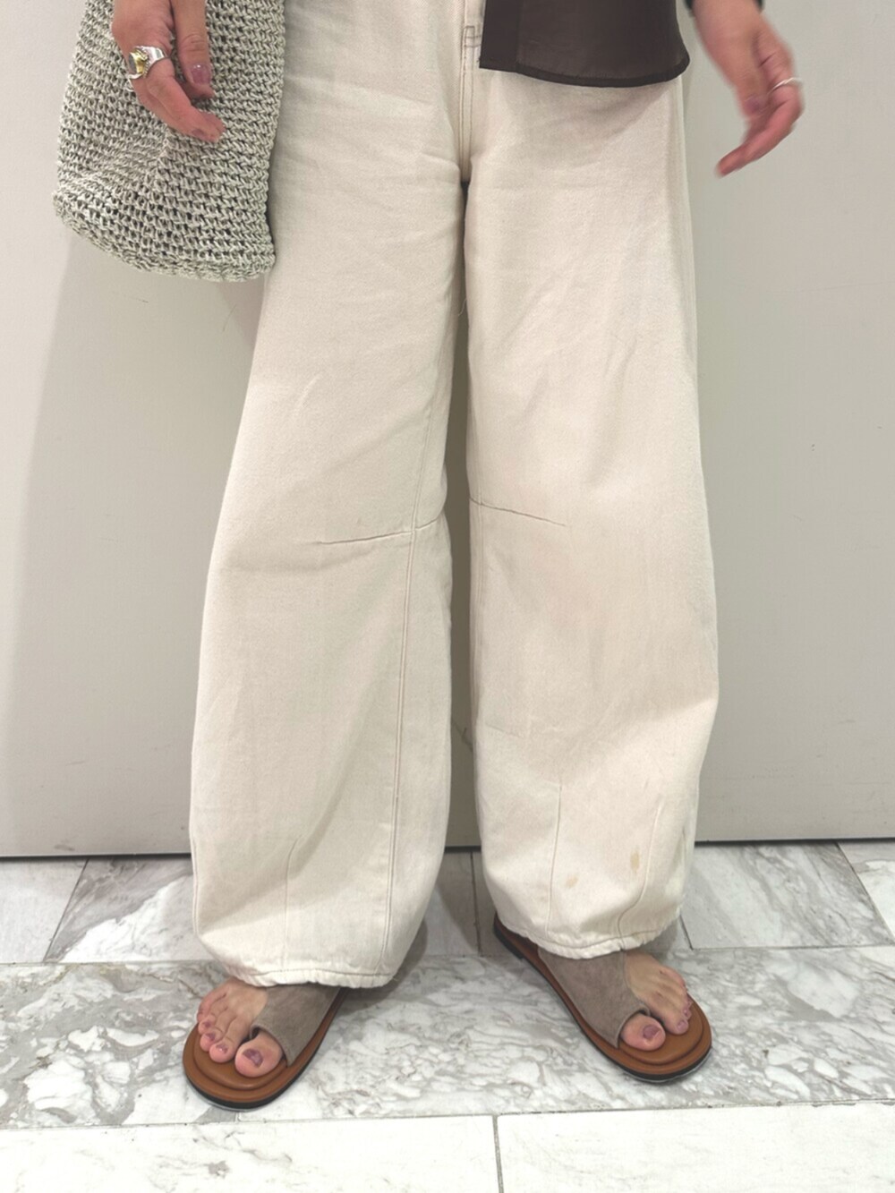 ブラウン系のシャツ/ブラウス、ホワイト系のデニムパンツ、グレー系のショルダーバッグを着用したレディースの夏コーディネートの6枚目の写真